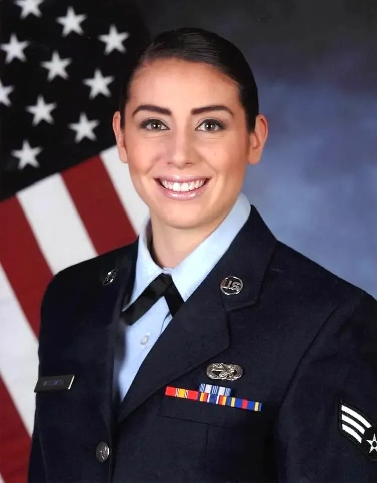 A woman in uniform is smiling for the camera.